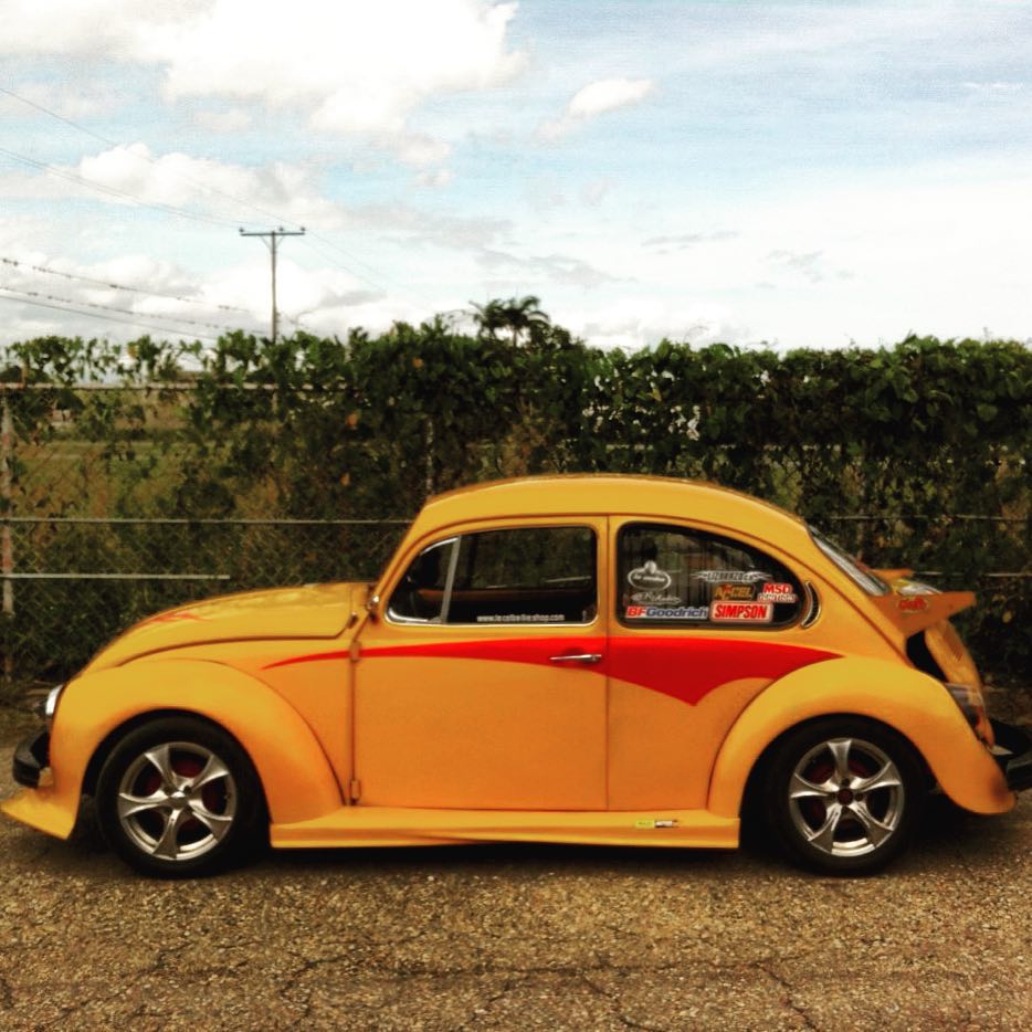 an orange vw bug parked on the side of the road