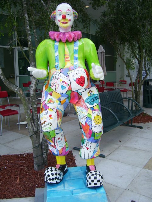 the clown statue is sitting in the yard