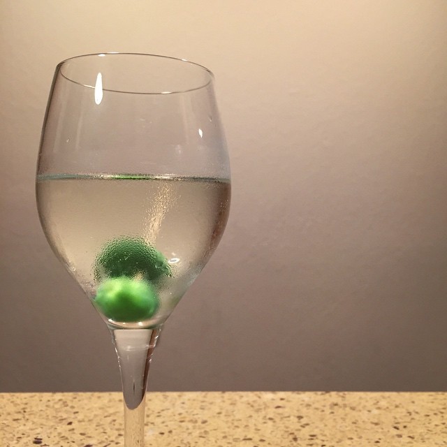 an empty wine glass with soing green inside it