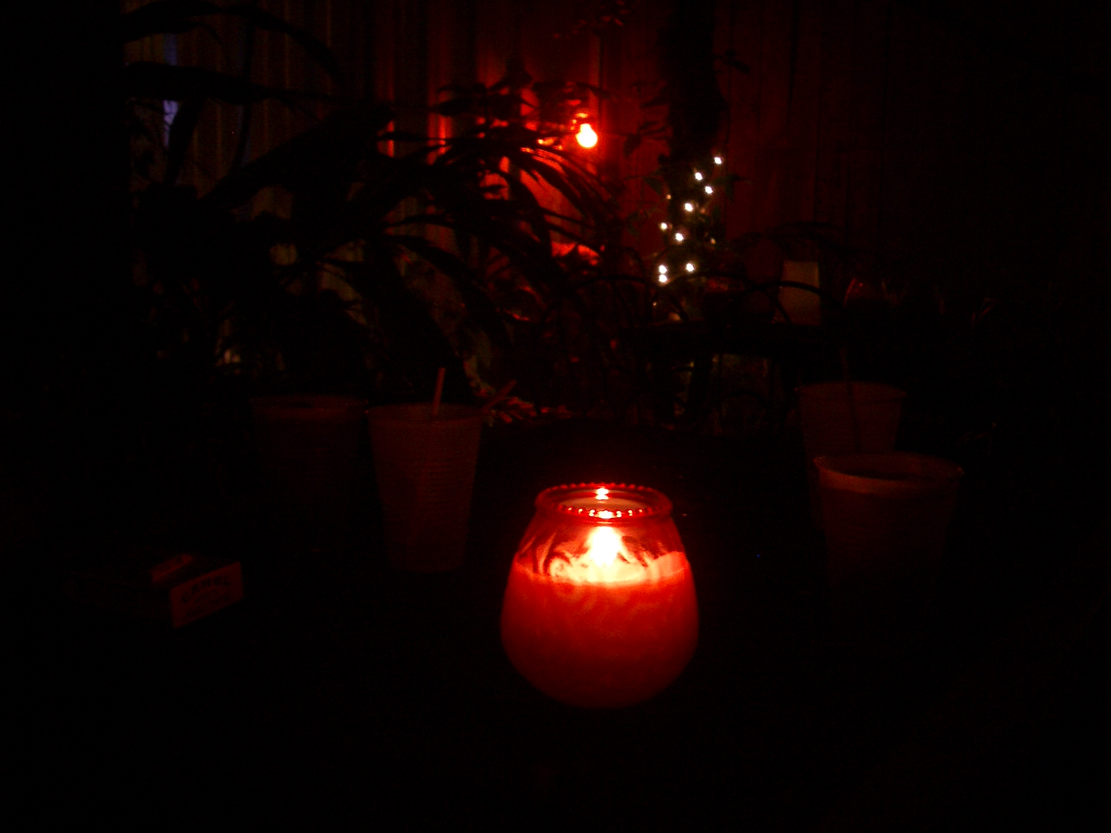 a small red candle sits in the dark