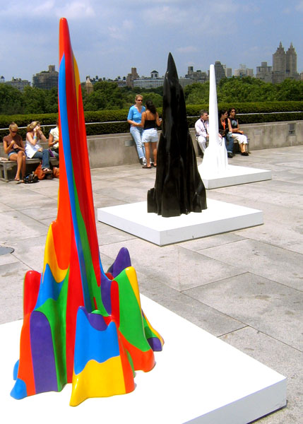 two sculptures of abstract shapes on display on a concrete slab