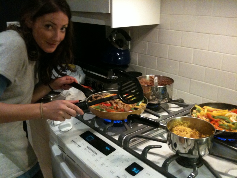 a woman standing over a stove cooking food