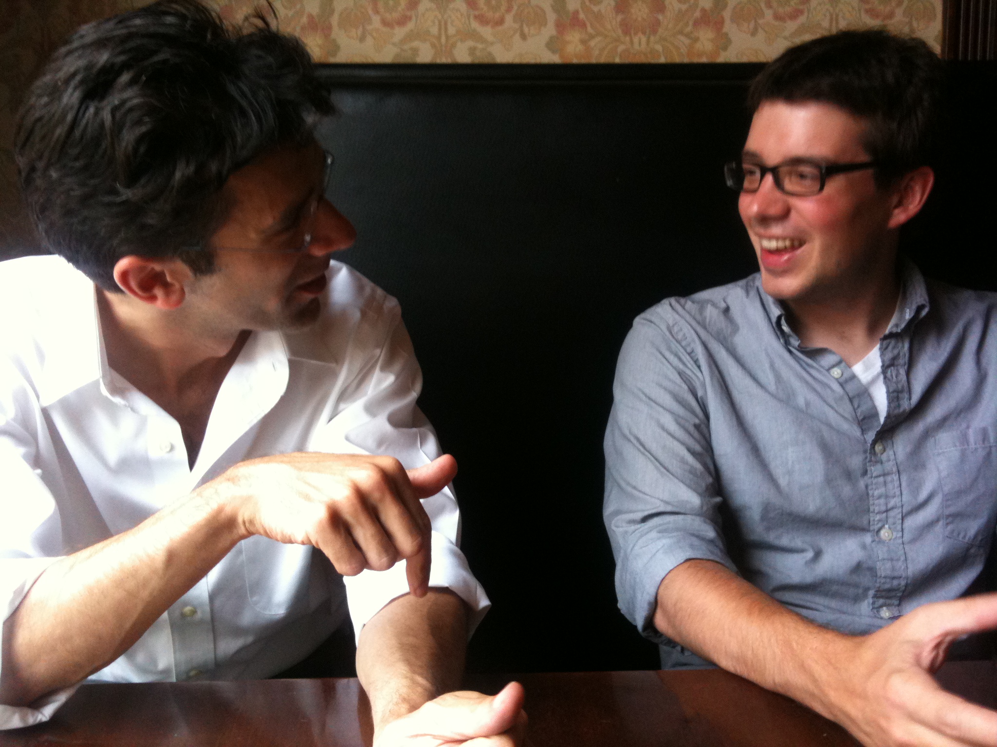 two men sitting next to each other at a table