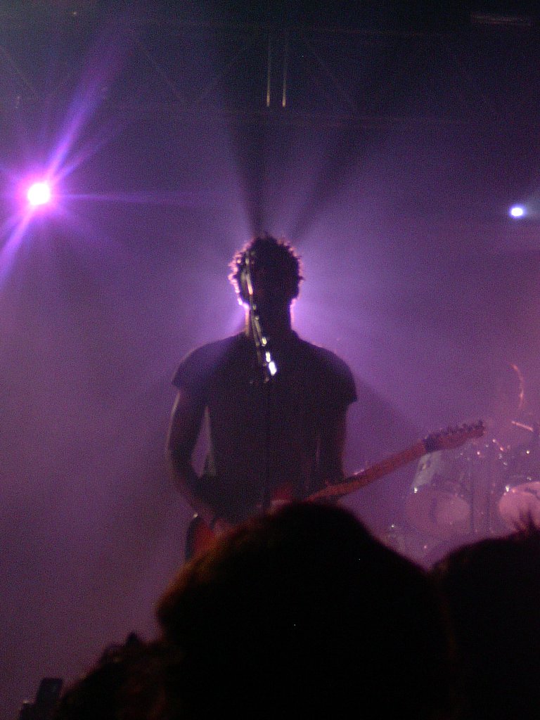 a guitarist on stage with lights and smoke
