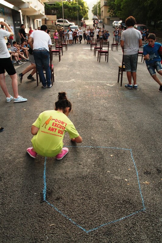 a  is drawing with chalk on the sidewalk