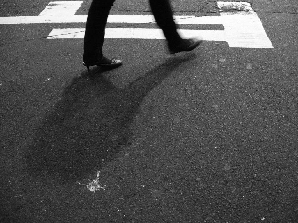 a man walking across a street next to a traffic light