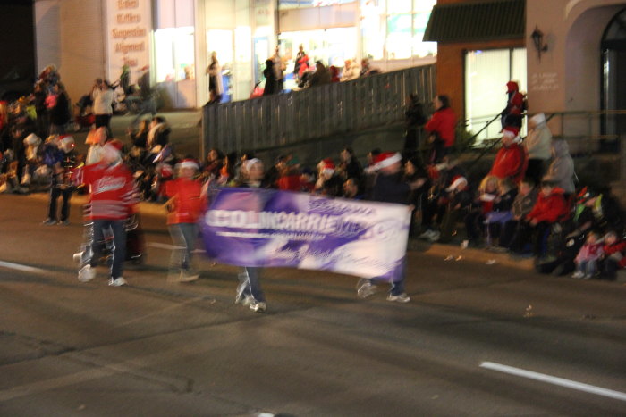 spectators watch an event with large banner in the street