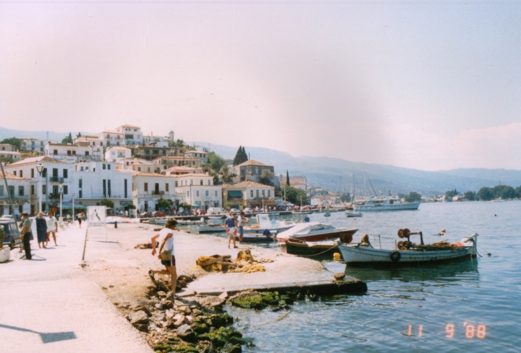 a group of people are standing on a dock next to some water