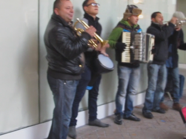 a band playing music outside in front of a building
