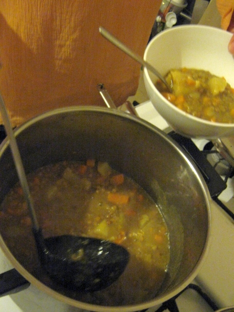 a bowl of soup and bowl of mussels on a stove