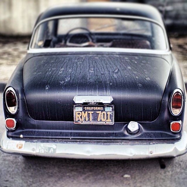 an old black american car with a license plate