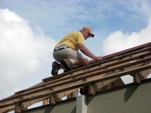 a man on the roof of a building working