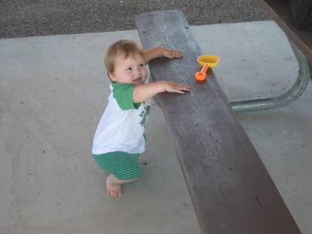a young baby in front of a wooden bench