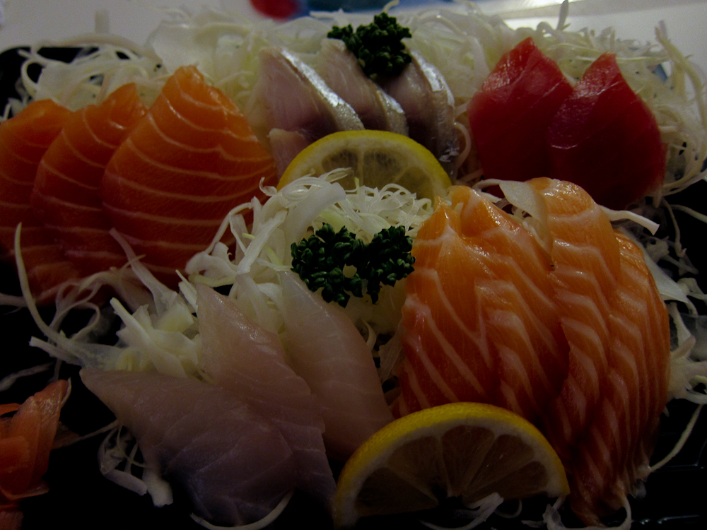 a tray with a variety of salmons and lemon slices