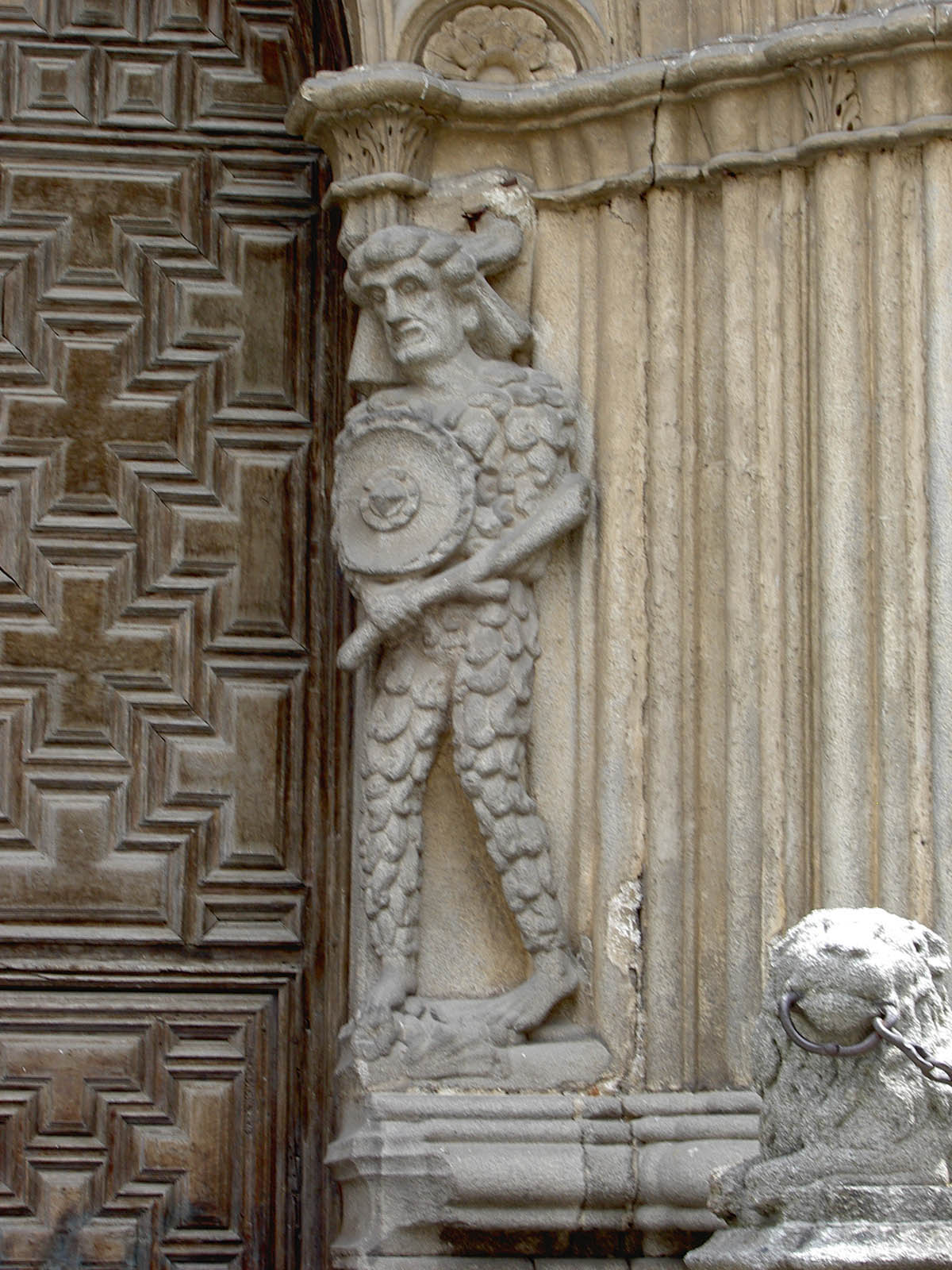 a statue of a man holding an instrument with a lion head on the side