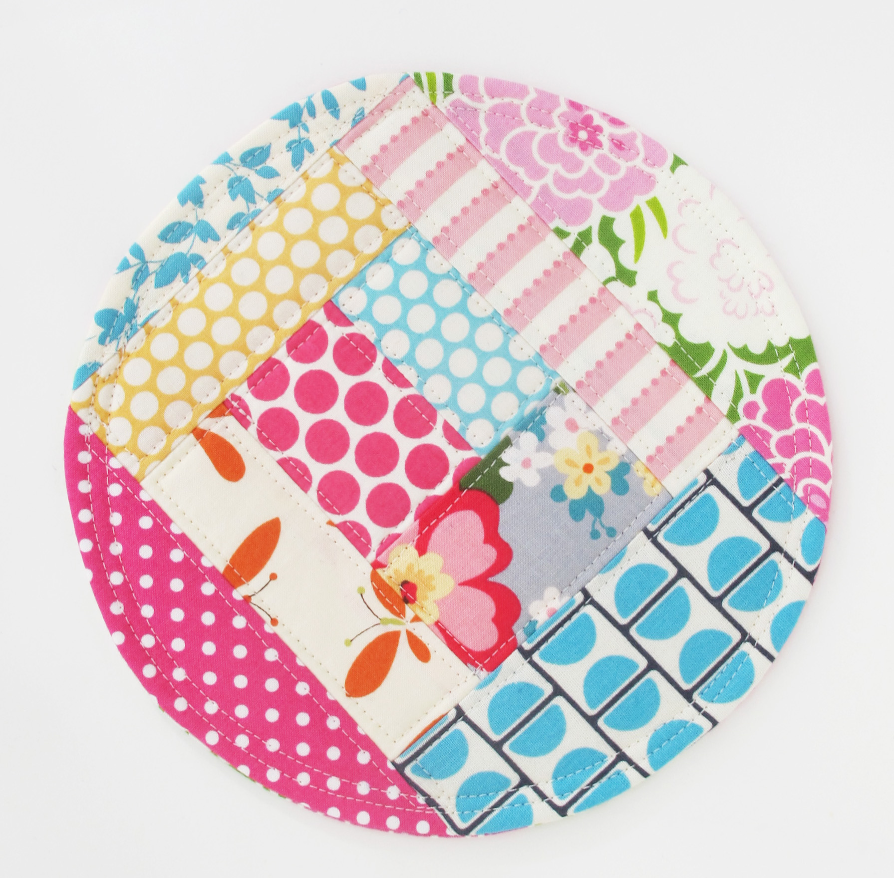 a multicolored patchwork cloth plate on white table