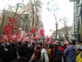a crowd of people holding red flags during a demonstration