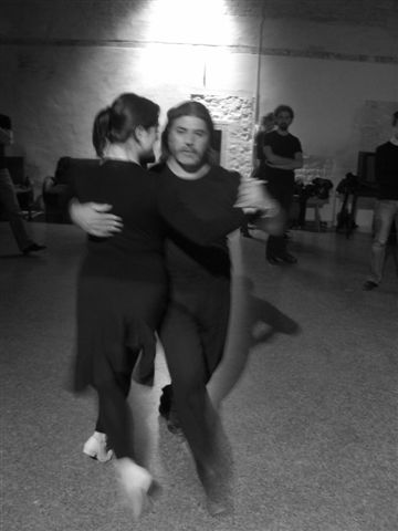 two people dancing in a dance studio with other people around