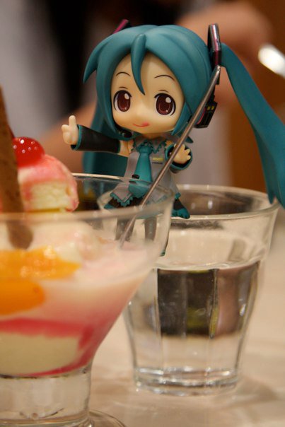 a doll with blue hair is standing near a drink