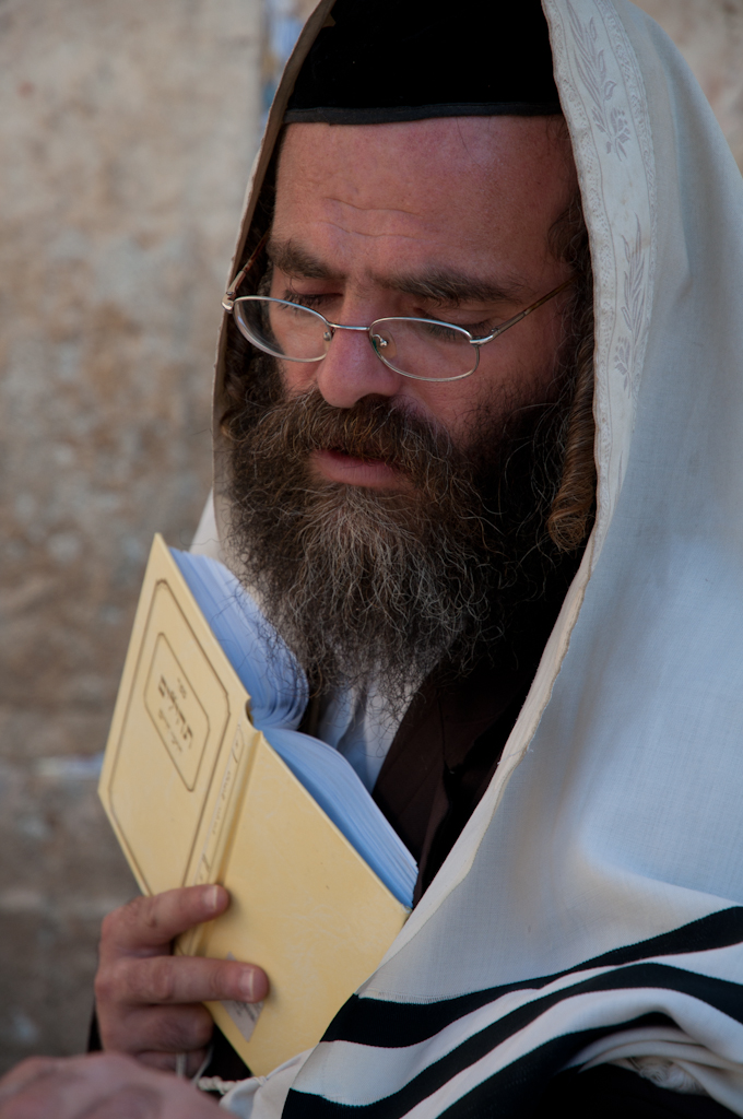 a man with glasses is holding an open book