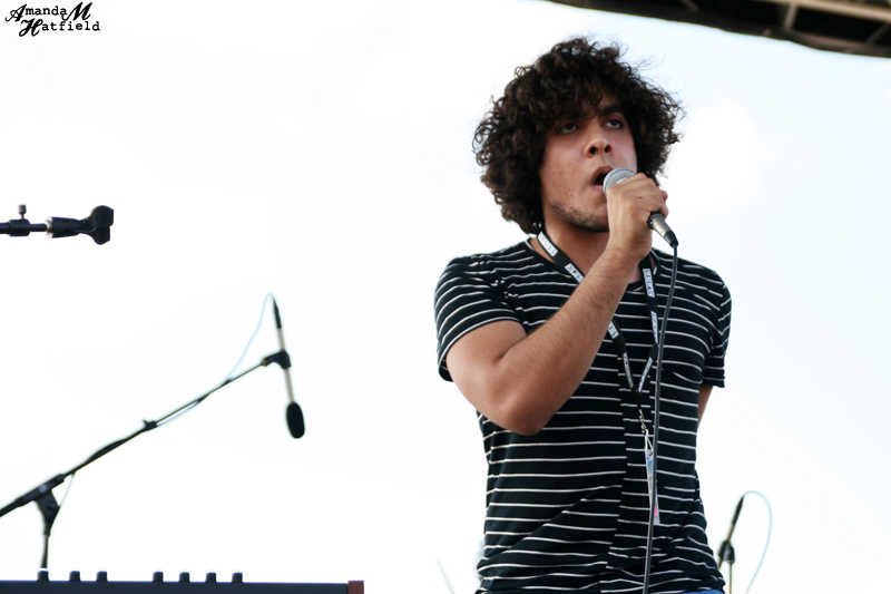 a young man singing on a stage with a microphone