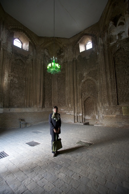 a woman standing inside a building under a light fixture