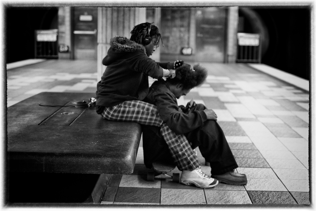 a  in plaid pants is sitting on a bench