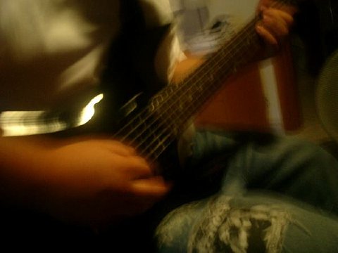 a man playing the bass guitar in a blurry image