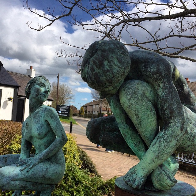 statues of a couple with their hands on their knees