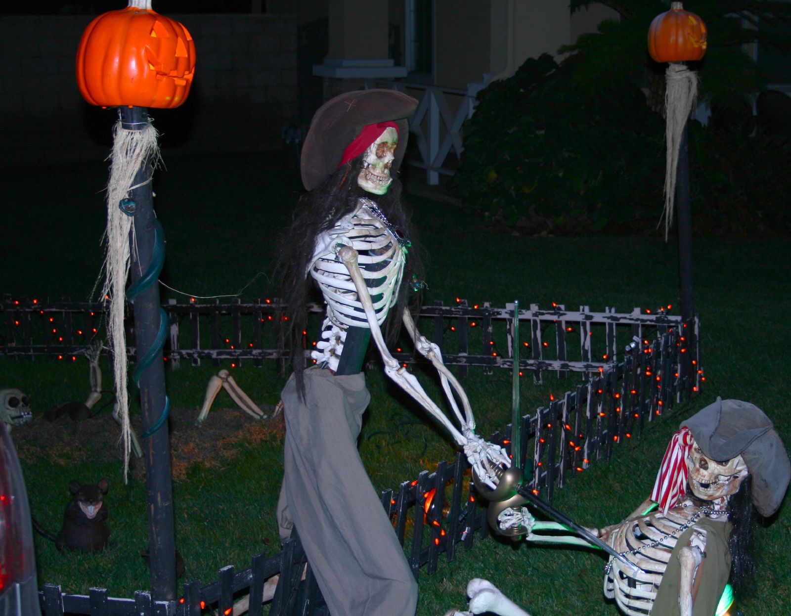 a man in a costume on display with skeletons and pumpkins