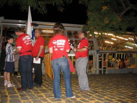 people standing together in front of a building wearing red t - shirts