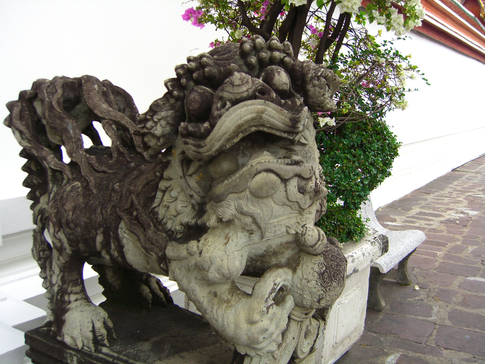 a dragon statue with green plants on it