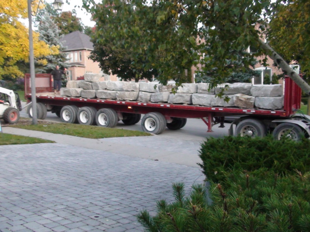 a large truck carrying large, raw rock behind it