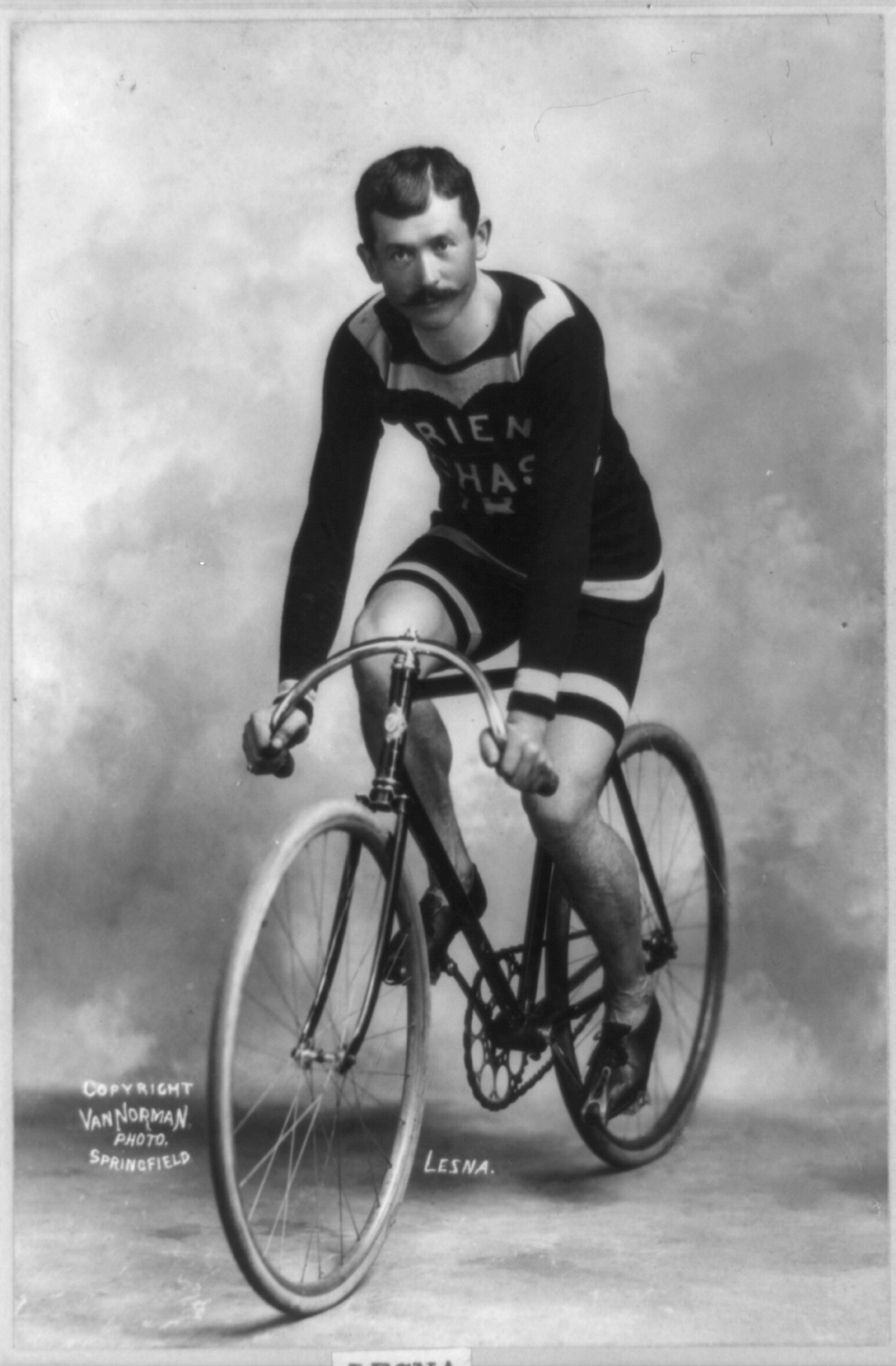 an old black and white po of a man riding a bicycle