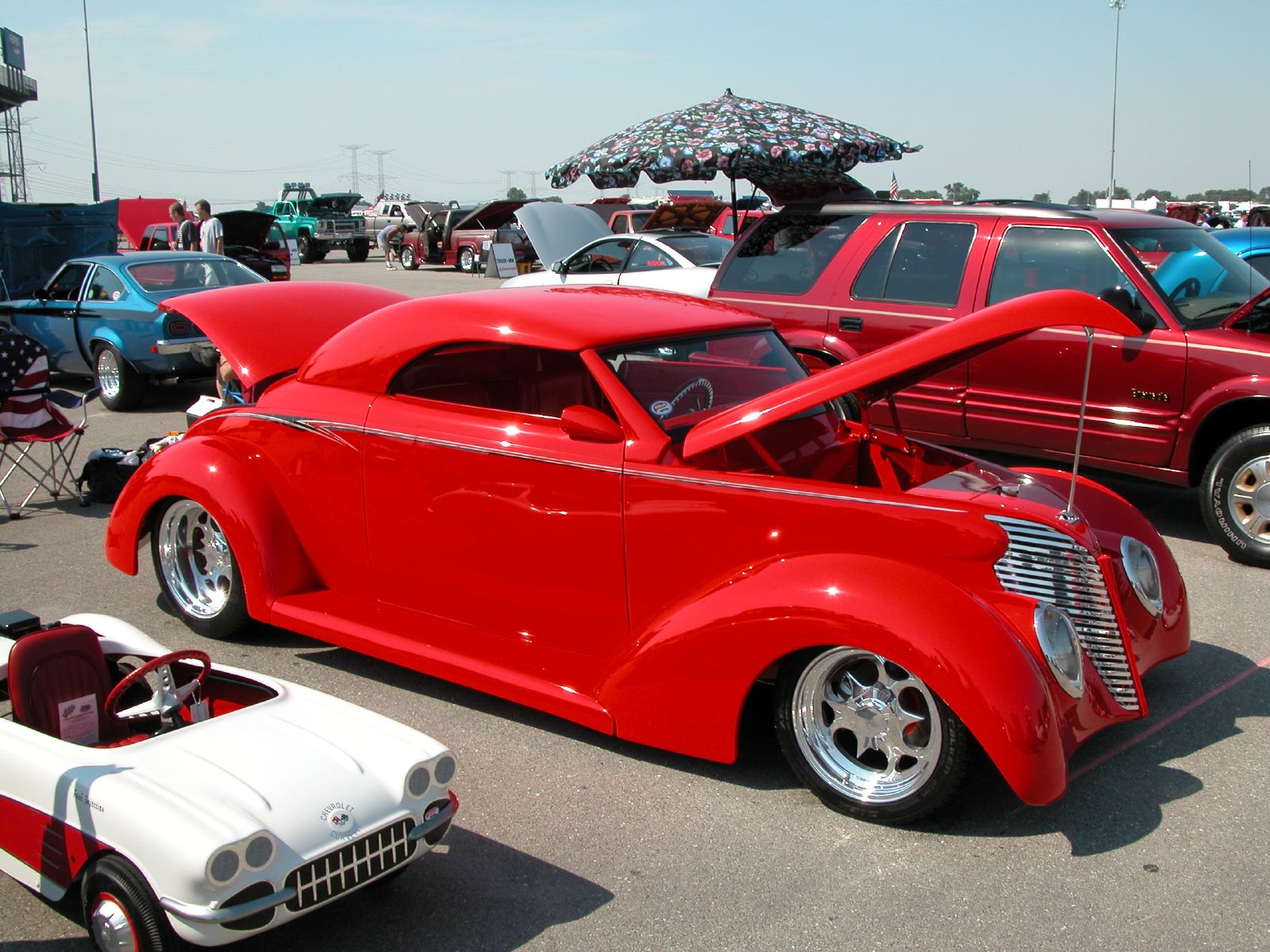 a number of cars parked in a lot with cars behind them