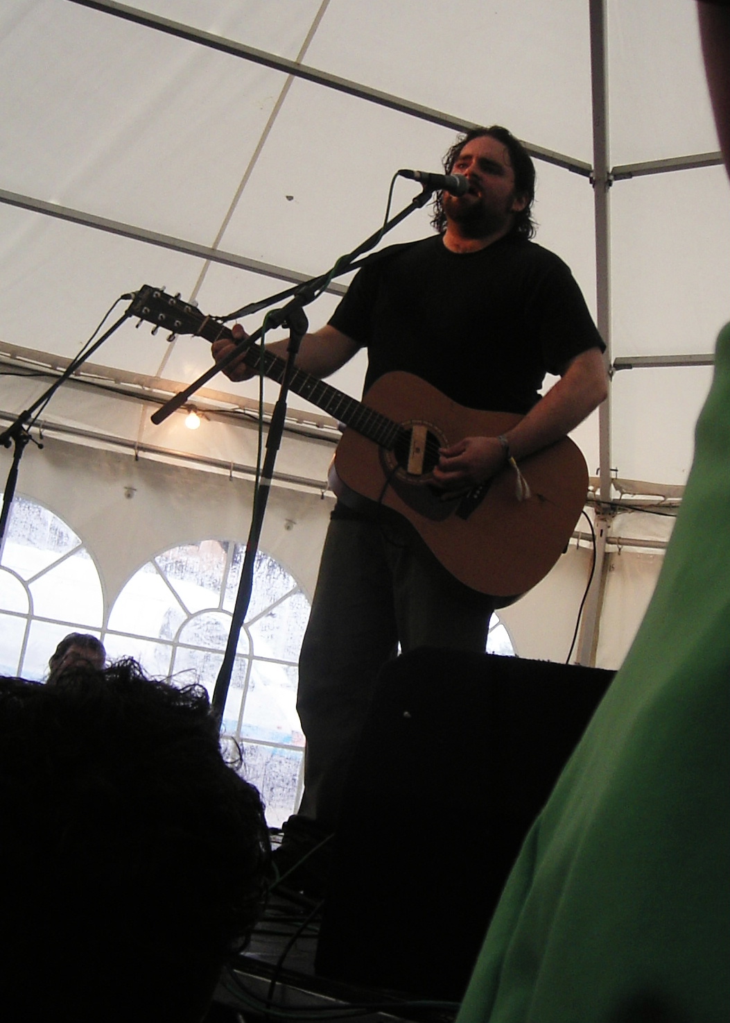 the man is playing the guitar in front of a crowd