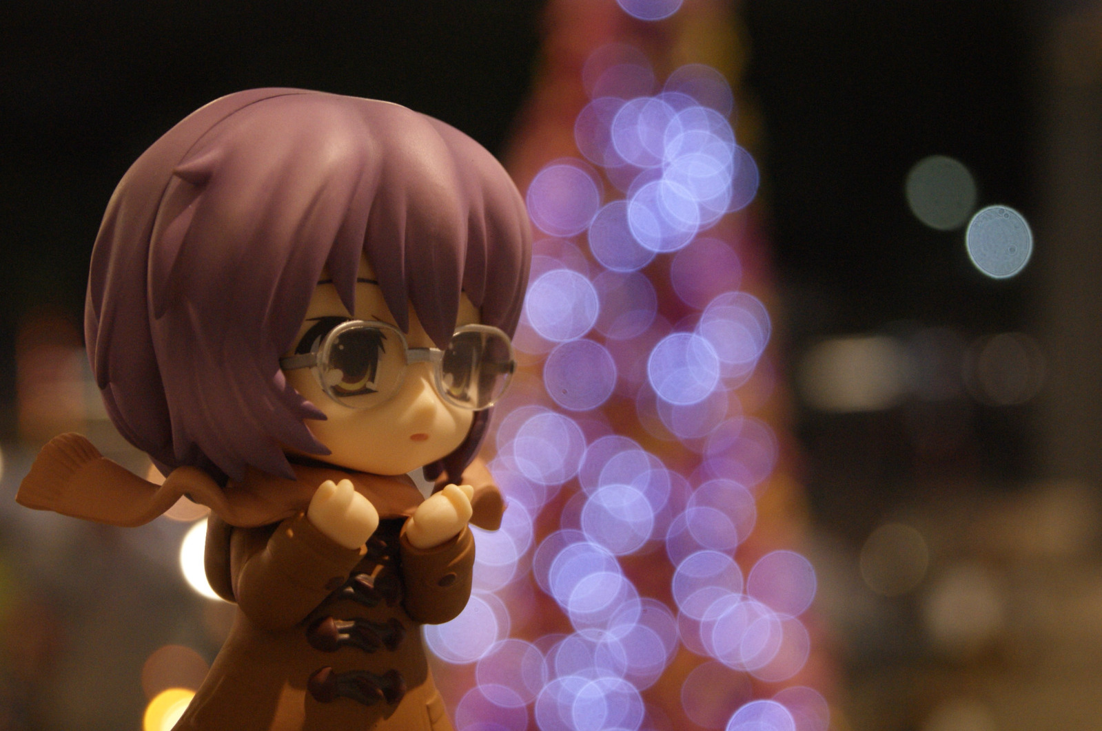 a cute figurine is next to a brightly lit christmas tree