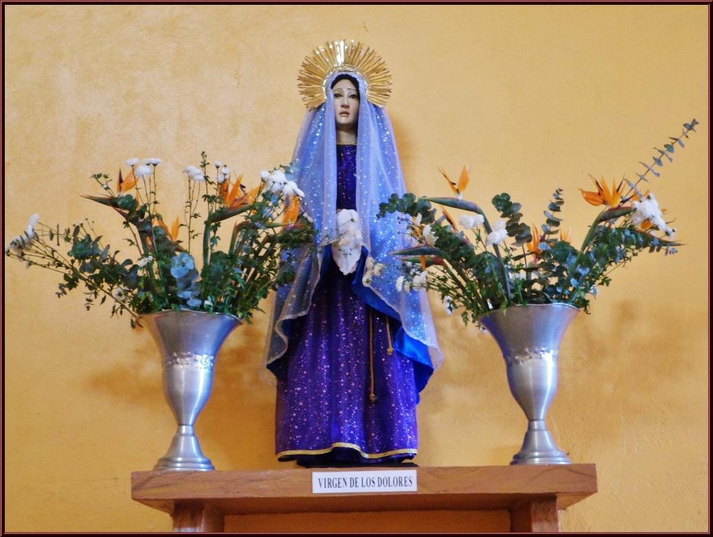 a statue on top of a shelf filled with flowers