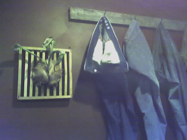 clothes hung next to a wall mounted ironing board