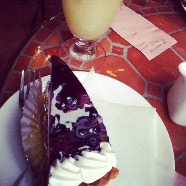 a slice of cake is on a plate with a fork and drink