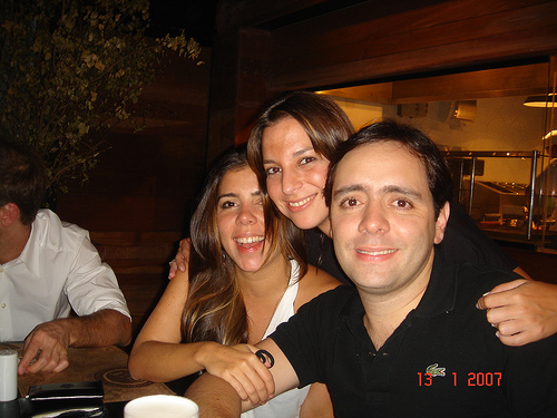 three people smiling with a man sitting in front of them