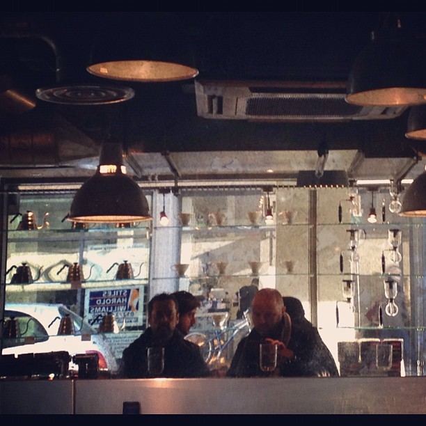 two men sitting at a bar with lots of lights