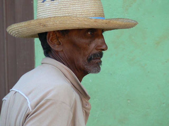 a man wearing a straw hat with an orange striped band