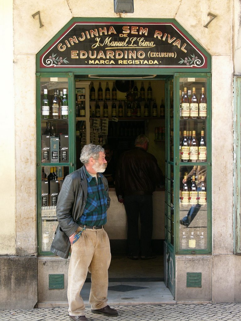 the man is standing outside of a wine shop