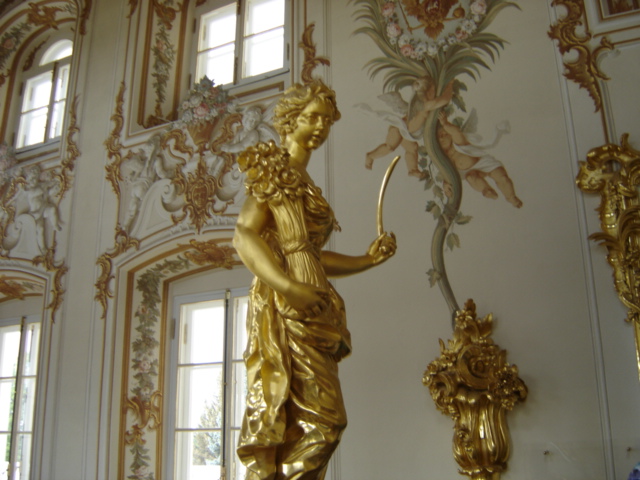 a decorative gilded wall with sculptures and windows