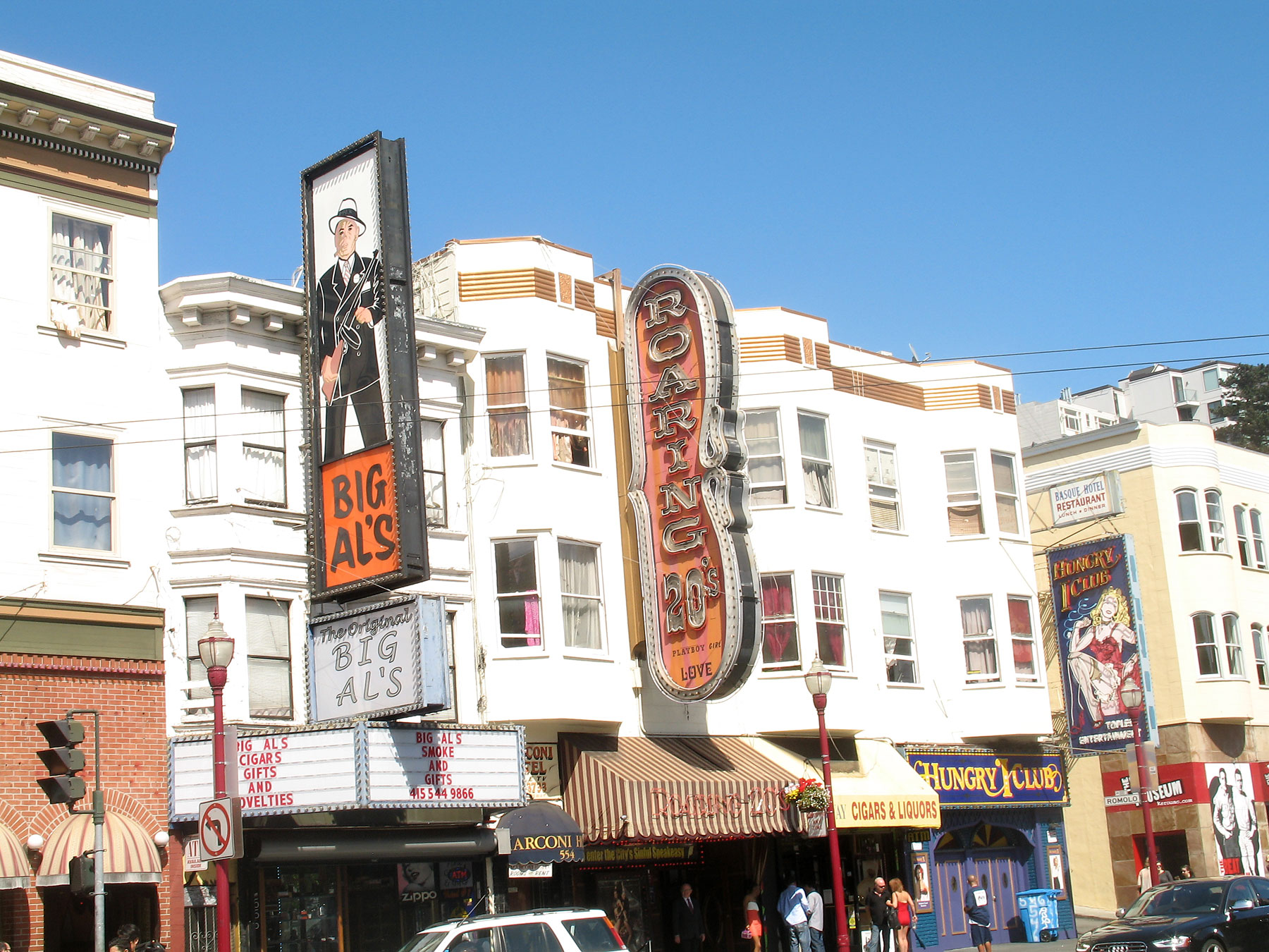 the front of a row of tall white buildings with signs on them