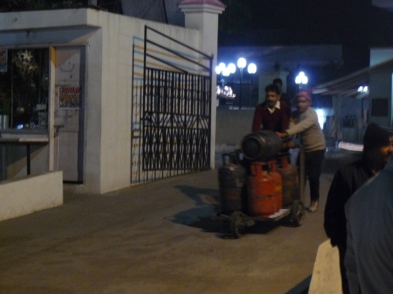 two people stand outside at night in front of a building