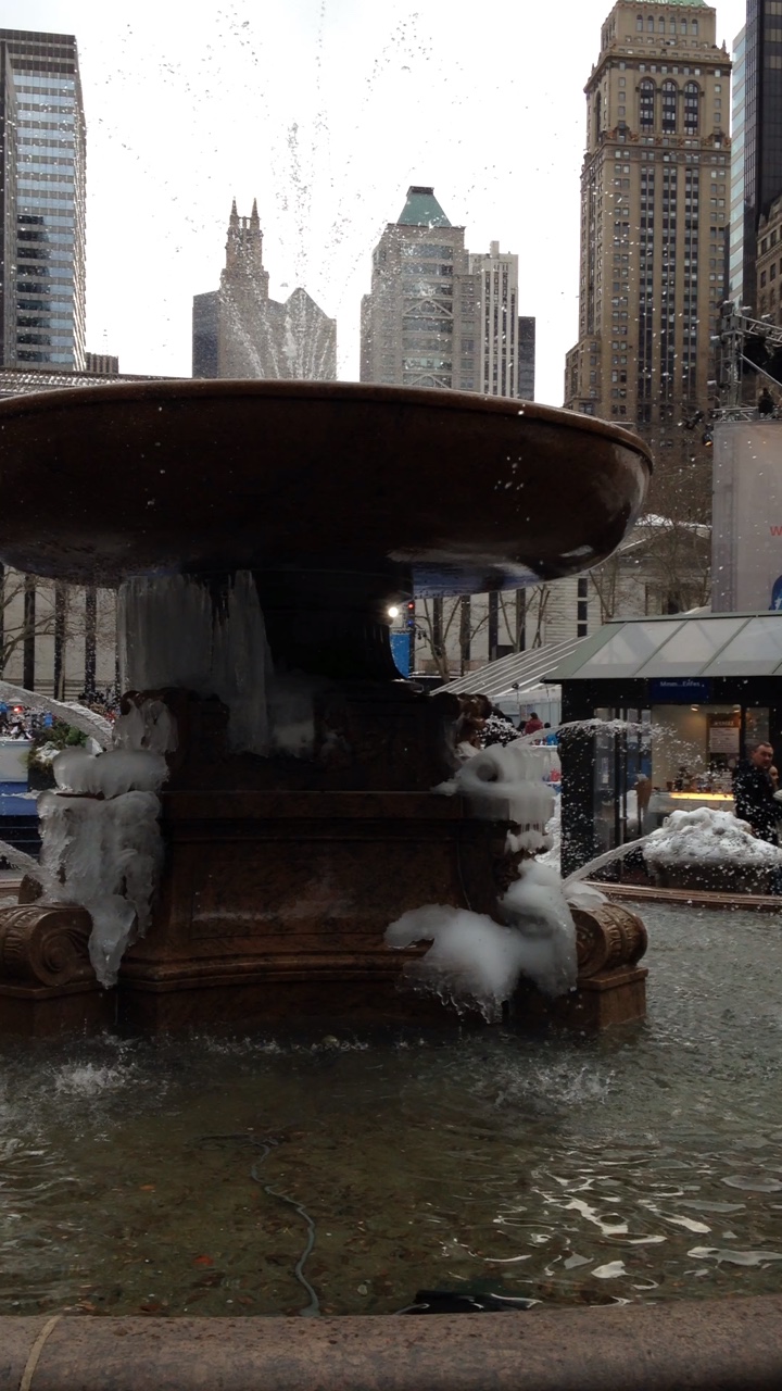 a water fountain in a city center with ice sprinkles