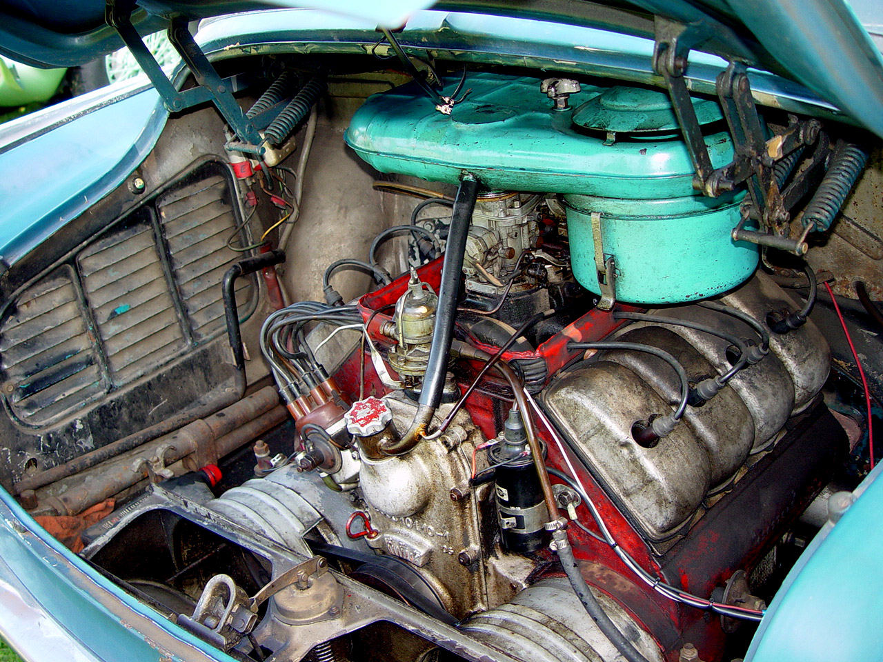 the engine compartment of an old, broken down blue car