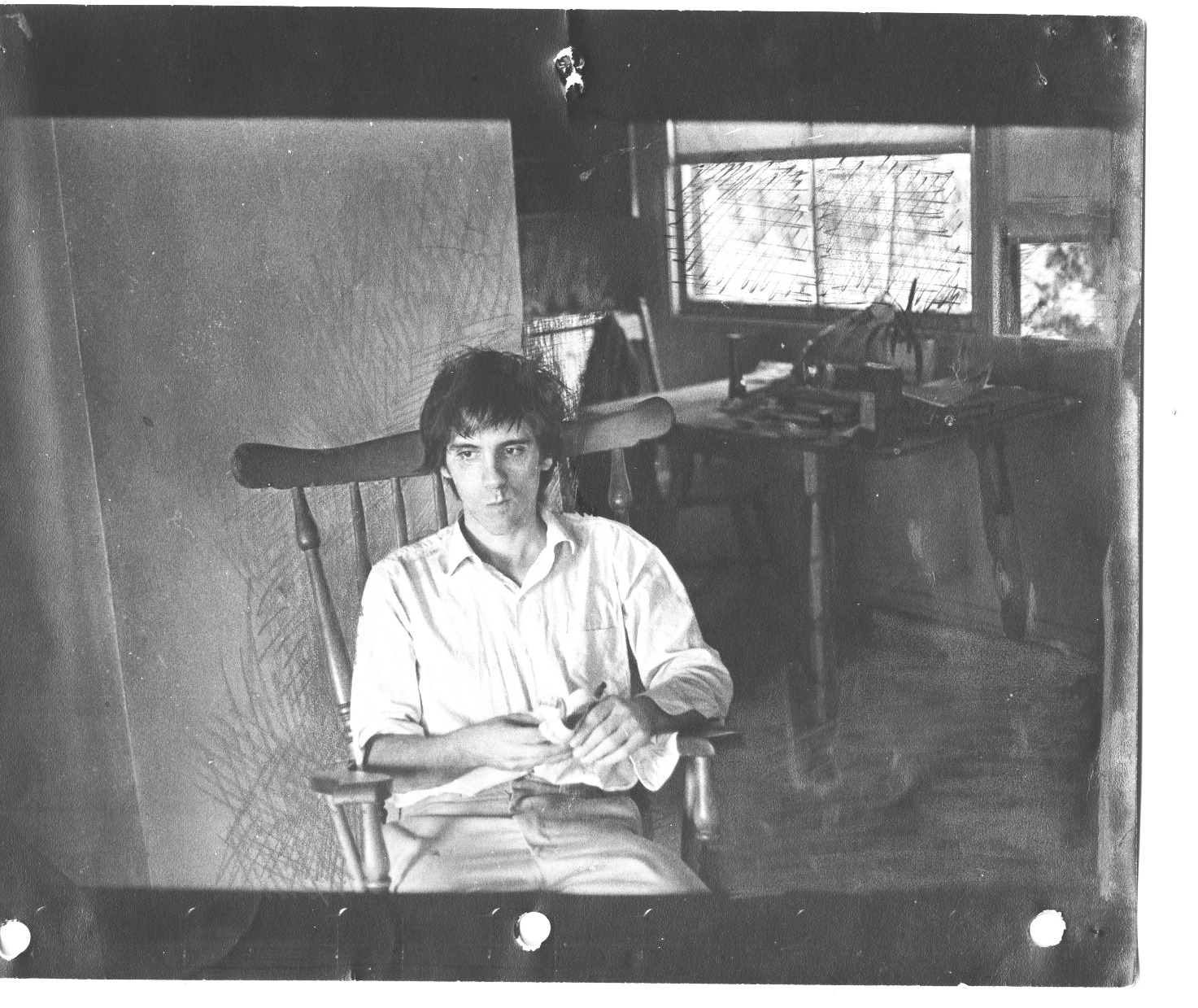 black and white po of man seated on chair in kitchen